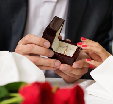 Man holding box with ring making propose to his girlfriend